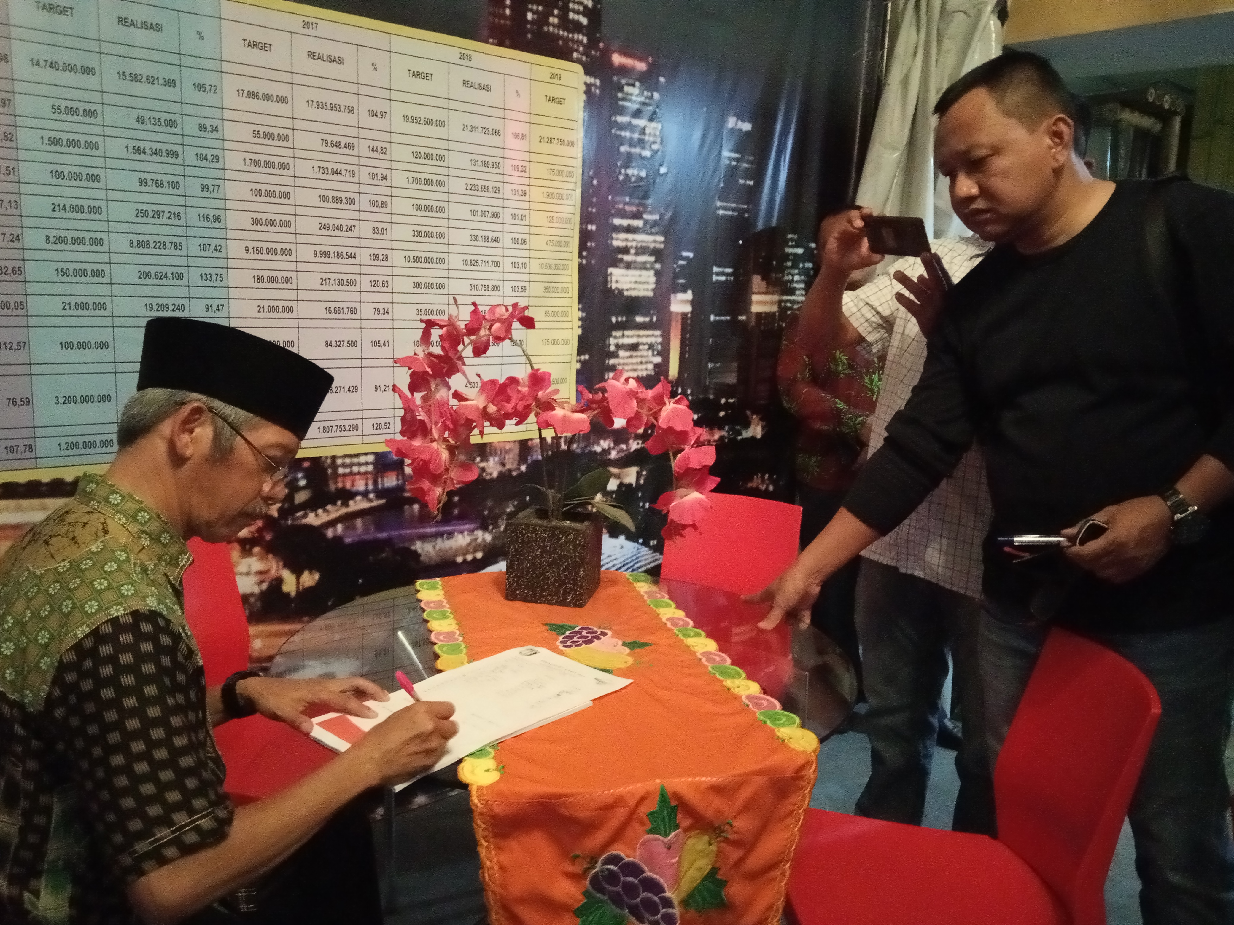 Bupati Pringsewu H Sujadi saat menuliskan catatan khusus di buku tamu di stand Bapenda
